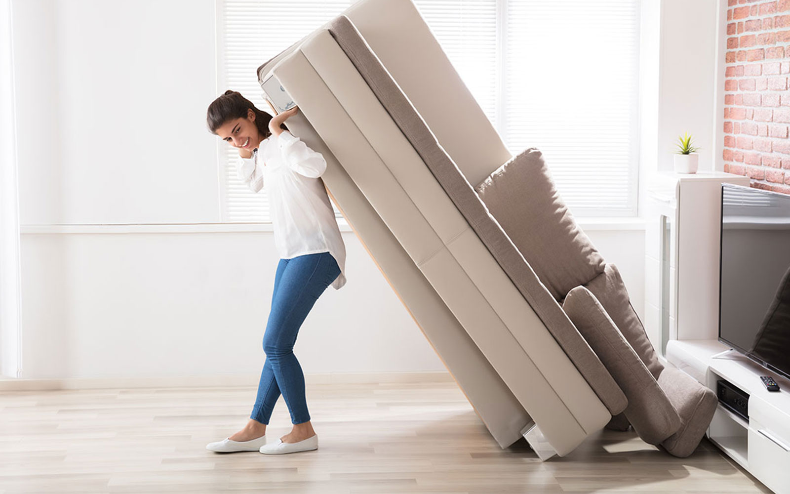 Lady moving sofa | Vallow Floor Coverings, Inc.